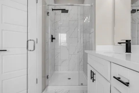 a spacious bathroom with a shower sink and mirror