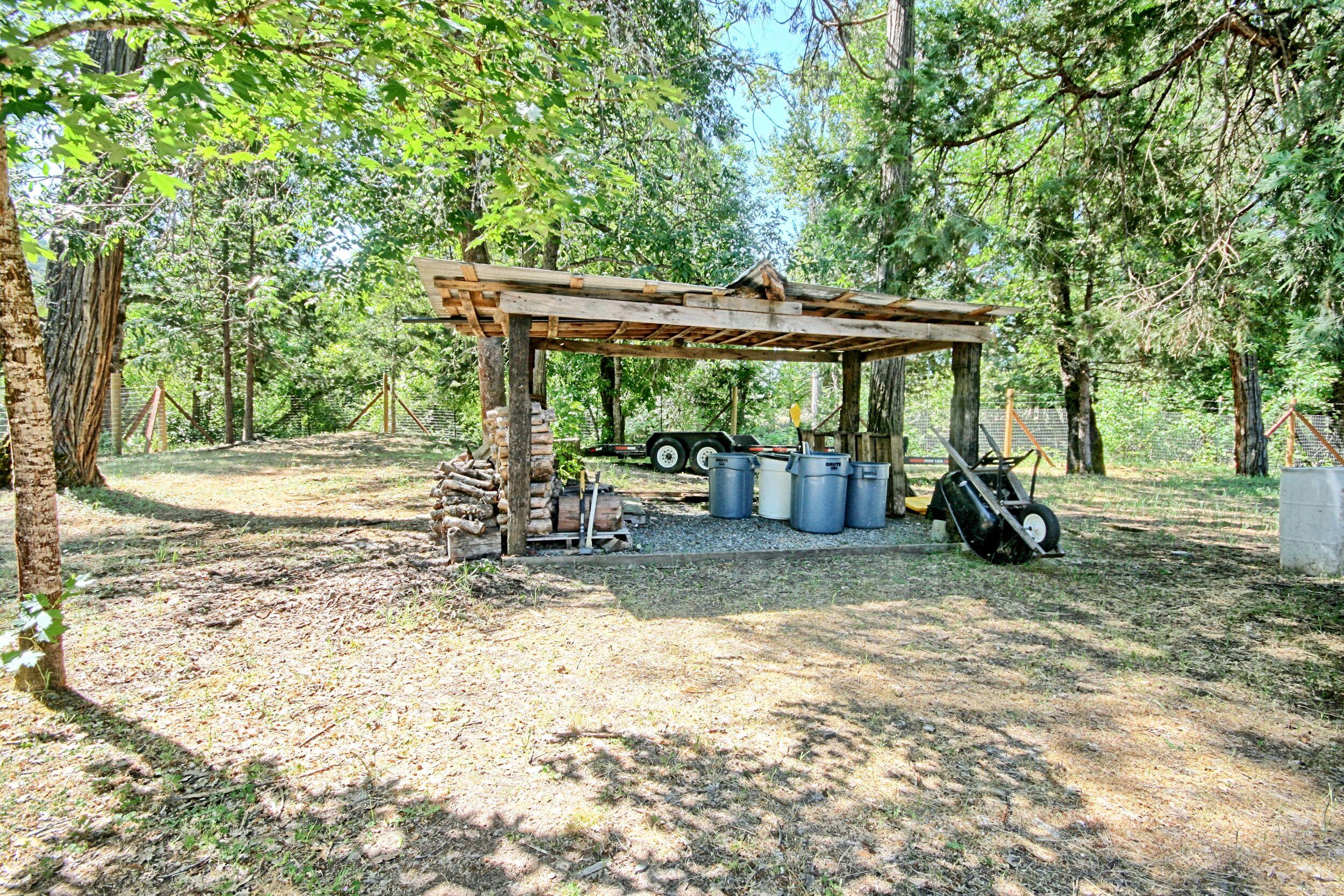 199 Powell Creek Road Williams, OR 97544 - Photo 45 of 57 a view of a patio with a table and chairs under an umbrella