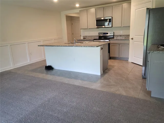 a kitchen with stainless steel appliances granite countertop a refrigerator stove microwave and sink