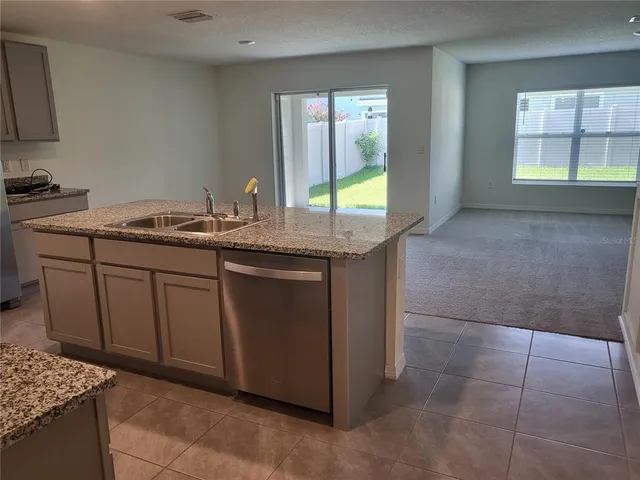 a kitchen with stainless steel appliances granite countertop a sink and a stove