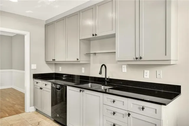 a kitchen with granite countertop white cabinets and black appliances