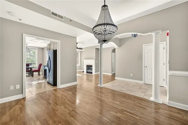 a view of a hallway with wooden floor and chandelier