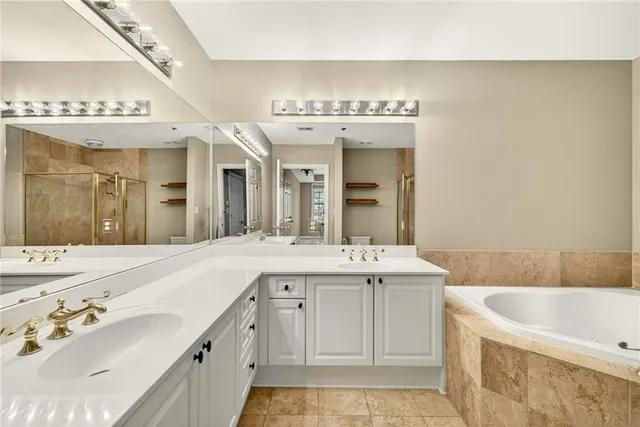 a spacious bathroom with a granite countertop sink mirror and bathtub