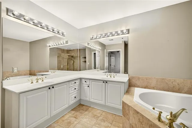 a spacious bathroom with a bathtub a sink and a mirror
