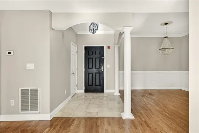 a view of a hallway with wooden floor and a cabinet