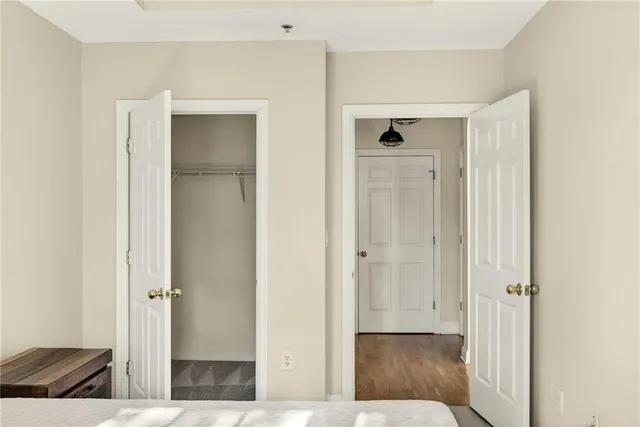 a view of a hallway with wooden floor and closet