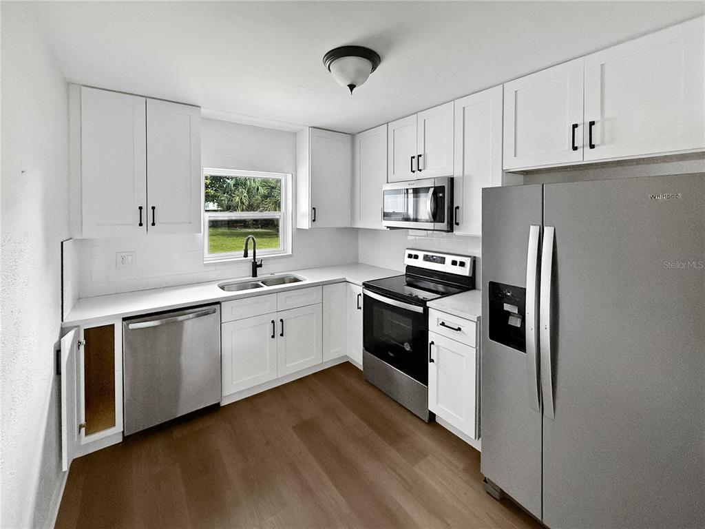 3511 Backspin Lane Orlando, FL 32804 - Photo 5 of 15 a kitchen with stainless steel appliances a refrigerator sink and cabinets
