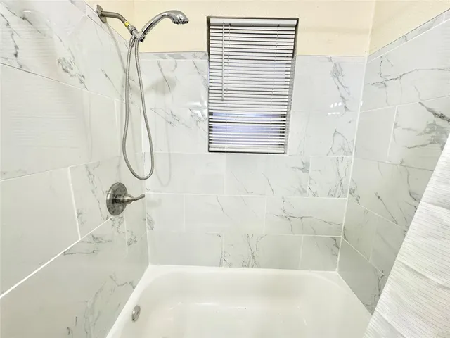 a bathroom with a white bath tub and shower