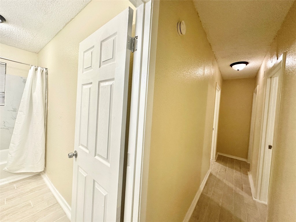 4302 Scottsdale Road, Unit B Austin, TX 78721 - Photo 19 of 37 Hall featuring a textured ceiling and baseboards