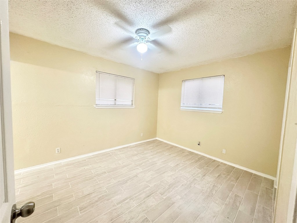 4302 Scottsdale Road, Unit B Austin, TX 78721 - Photo 24 of 37 Unfurnished room with wood tiled floors, a textured ceiling, and ceiling fan