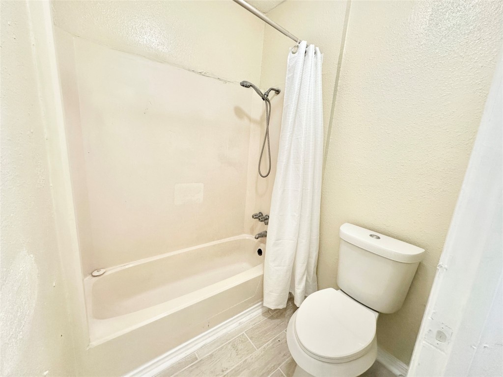 4302 Scottsdale Road, Unit B Austin, TX 78721 - Photo 27 of 37 Bathroom with shower / tub combo, a textured wall, and wood finish floors