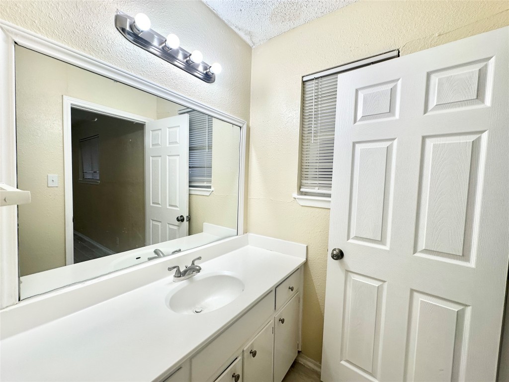 4302 Scottsdale Road, Unit B Austin, TX 78721 - Photo 29 of 37 Bathroom with a textured wall, vanity, and a textured ceiling