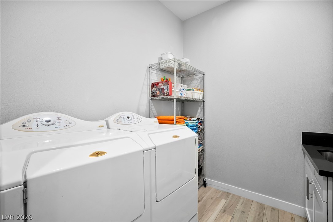 432 North Racetrack Road Henderson, NV 89015 - Photo 10 of 45 Laundry area featuring washing machine and dryer, light wood-style flooring, and cabinet space