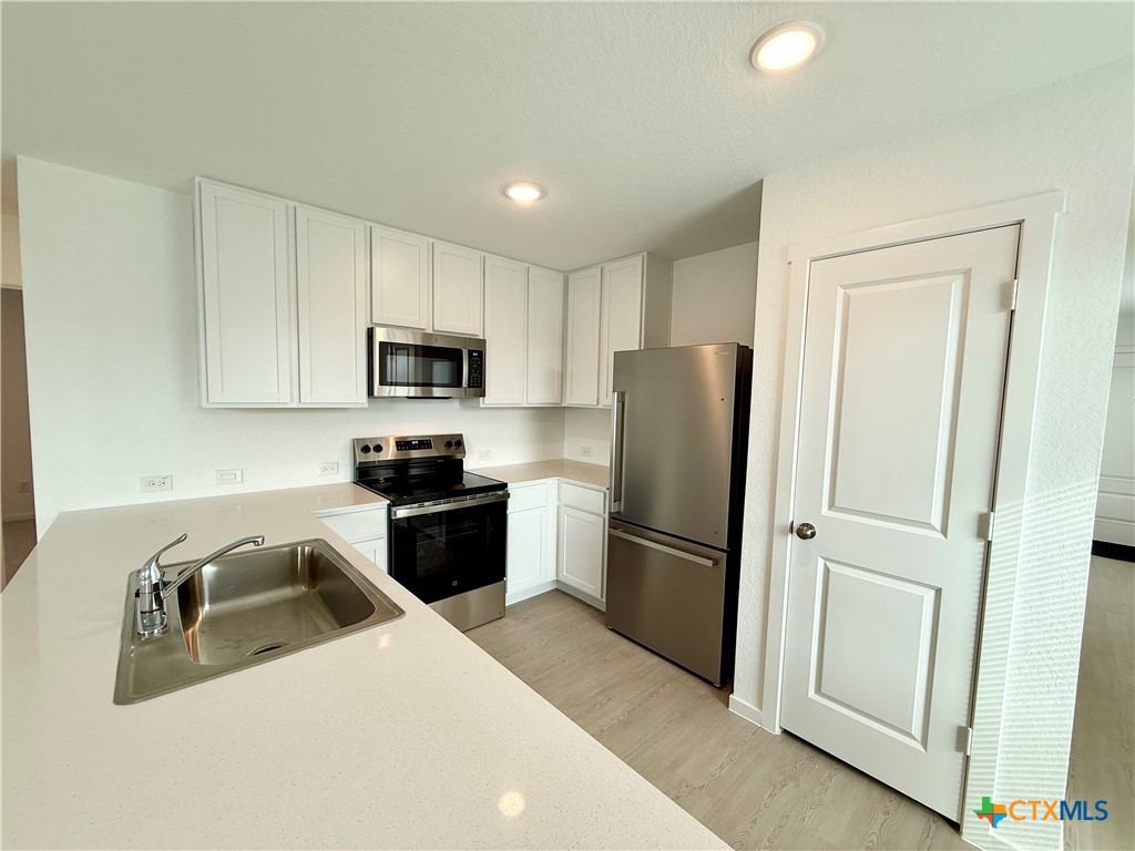 311 Moscato Road New Braunfels, TX 78130 - Photo 8 of 38 a kitchen with granite countertop a refrigerator and a sink