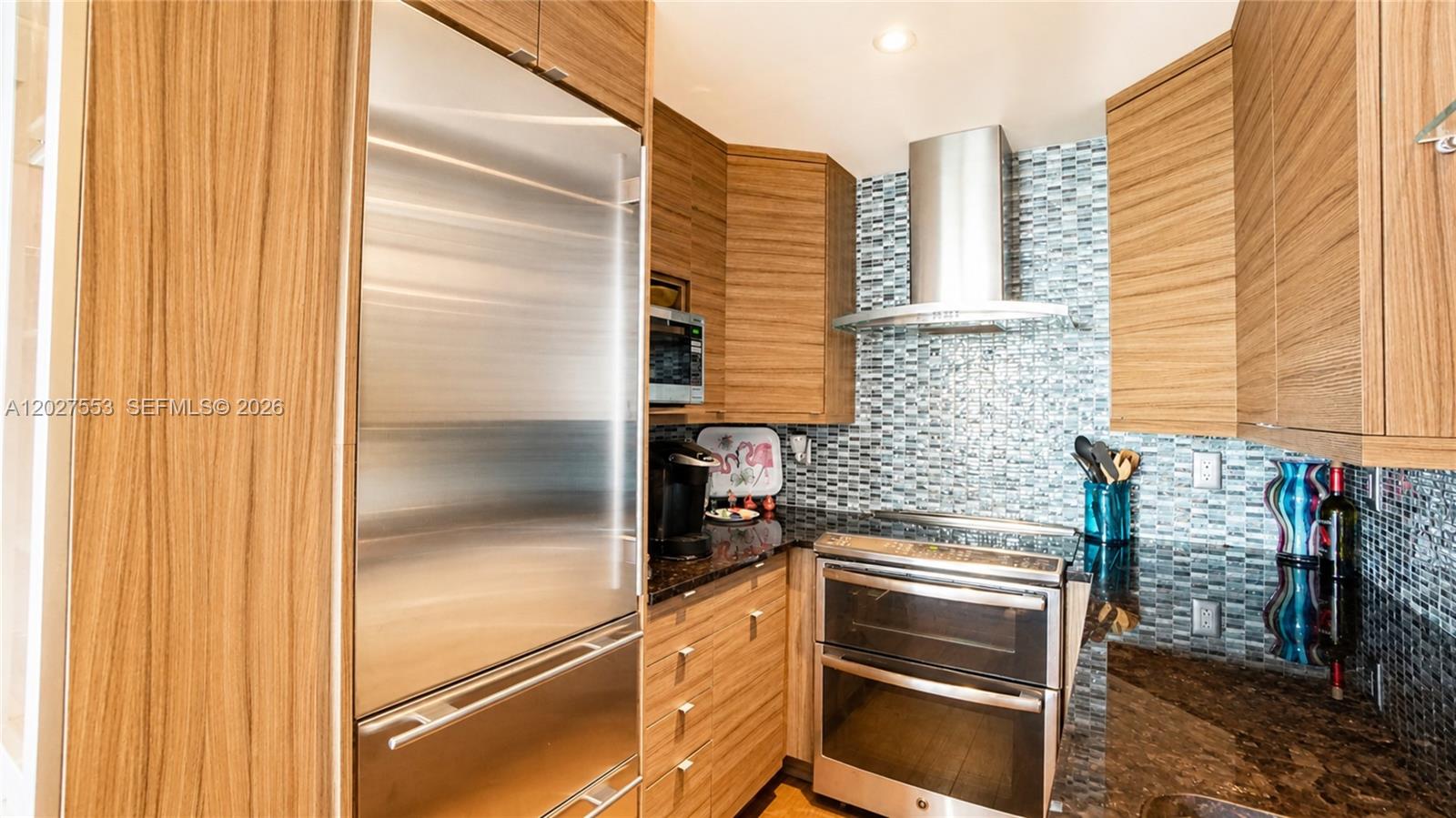 100 Lincoln Road, Unit 533 Miami Beach, FL 33139 - Photo 9 of 26 a kitchen with a refrigerator and cabinets