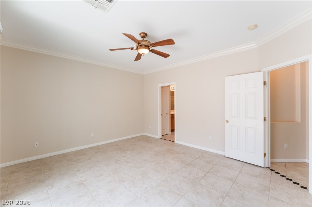 10481 Riverside Park Avenue Las Vegas, NV 89135 - Photo 19 of 51 Unfurnished bedroom with ceiling fan, crown molding, ensuite bathroom, and light tile patterned floors