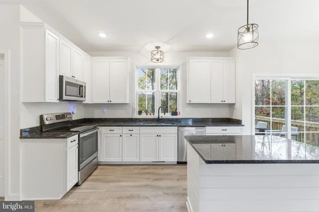 a kitchen with stainless steel appliances granite countertop a sink and a stove