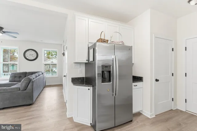 a living room with stainless steel appliances furniture and a large window