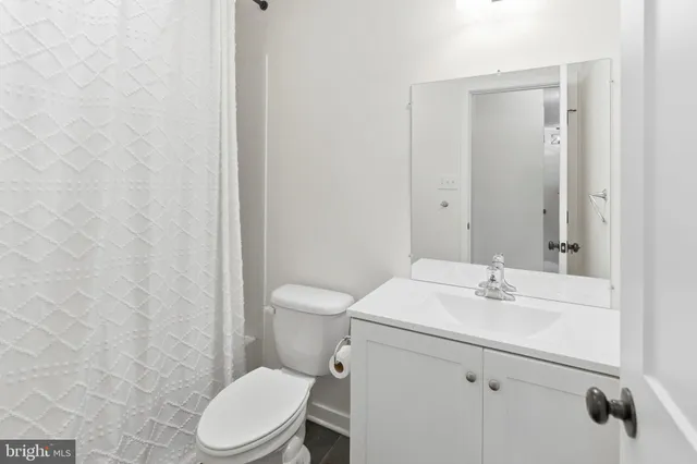 a bathroom with a sink a toilet and a mirror