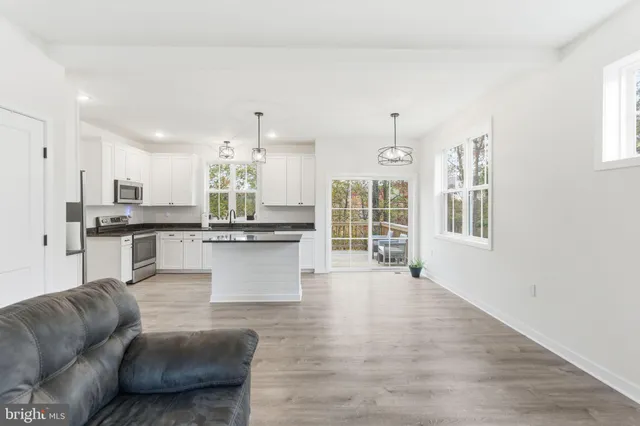 a living room with furniture and kitchen view