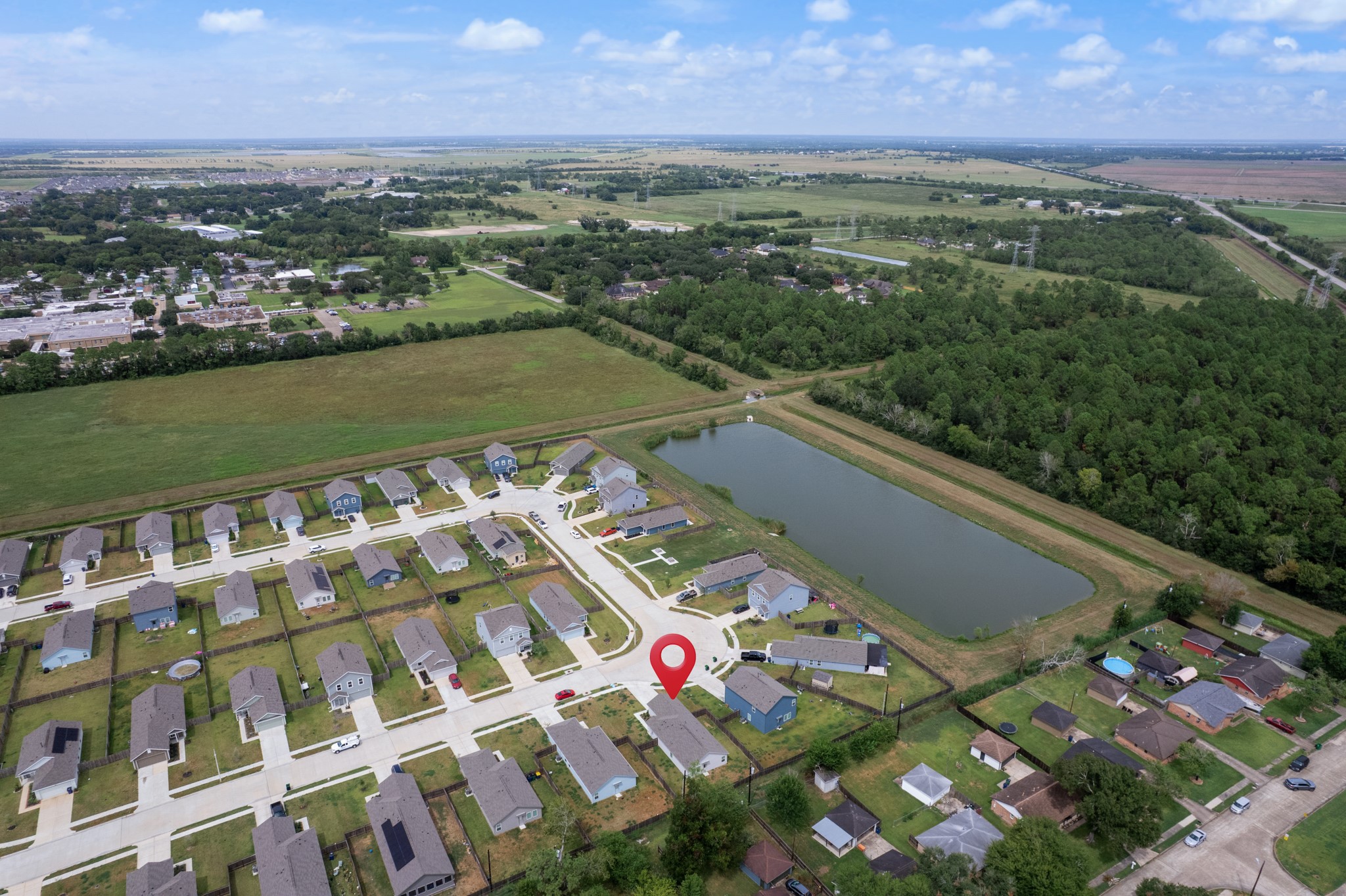 252 Houston Street Angleton, TX 77515 - Photo 45 of 49 Wide aerial view showcases the neighborhood layout, nearby pond, and surrounding green space, with the property clearly marked.