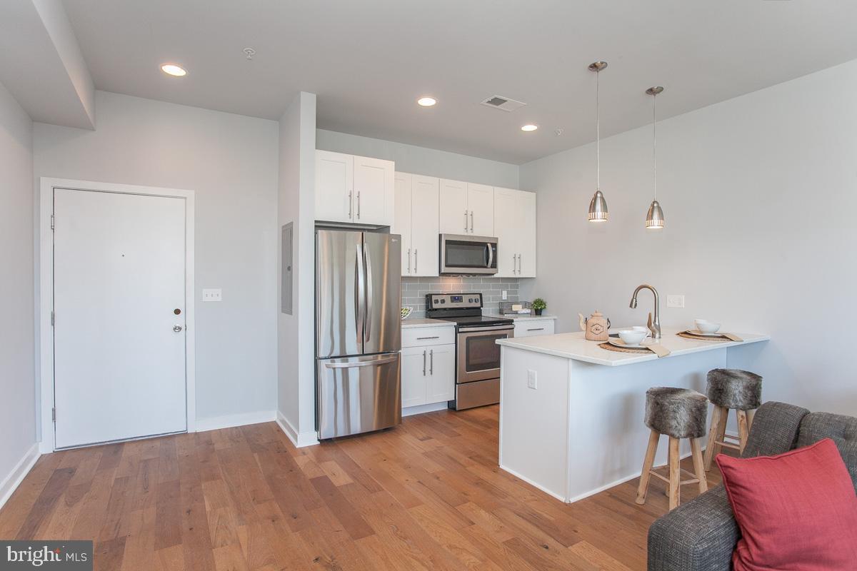 5938 Henry Avenue, Unit 12 Philadelphia, PA 19128 - Photo 11 of 19 a kitchen with stainless steel appliances a refrigerator stove microwave and sink