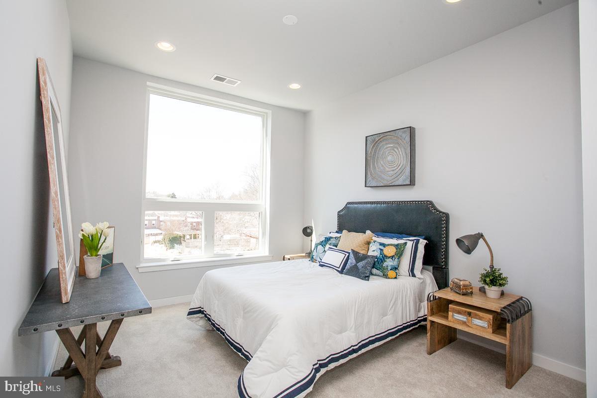 5938 Henry Avenue, Unit 12 Philadelphia, PA 19128 - Photo 14 of 19 a bedroom with a bed a window and potted plant