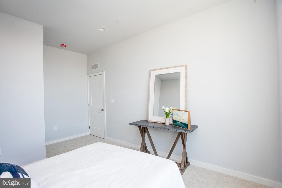 5938 Henry Avenue, Unit 12 Philadelphia, PA 19128 - Photo 17 of 19 a bedroom with a bed and a mirror