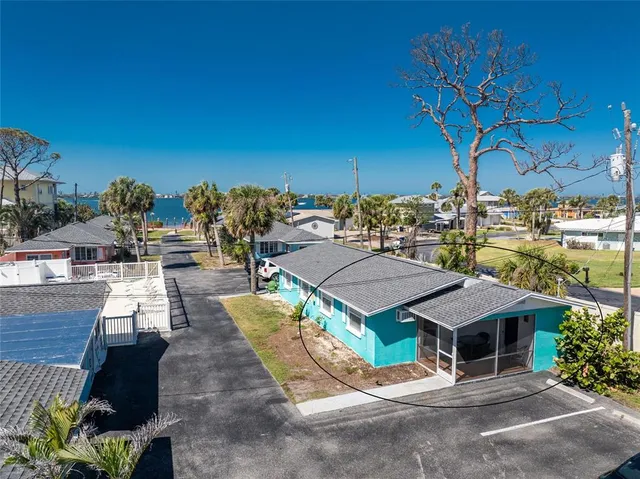 a view of a patio with couches table and chairs under an umbrella