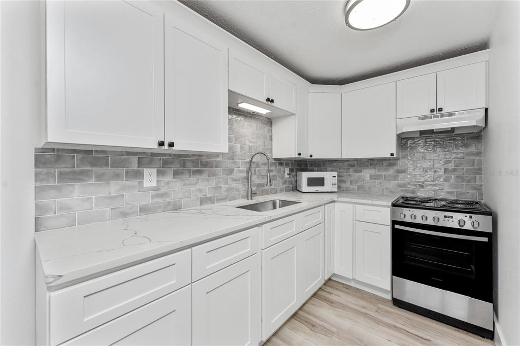 470 South McCall Road, Unit 10 Englewood, FL 34223 - Photo 16 of 57 a kitchen with appliances a sink and cabinets