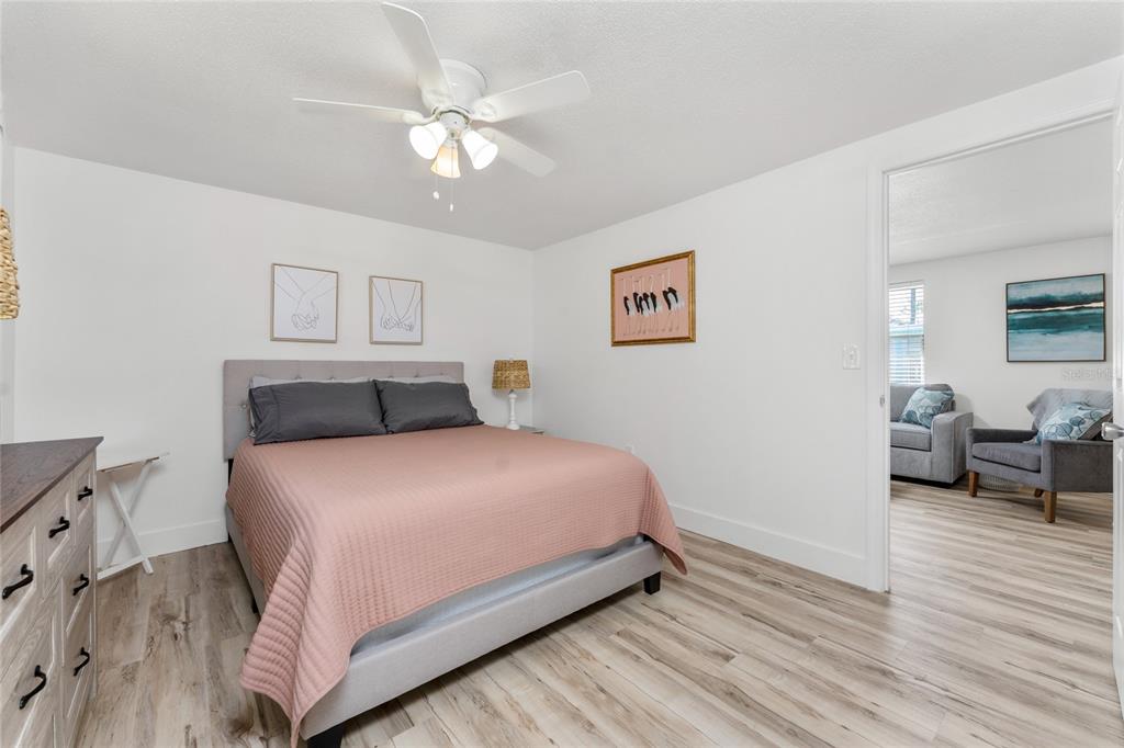 470 South McCall Road, Unit 10 Englewood, FL 34223 - Photo 21 of 57 a bedroom with a large bed and a chandelier