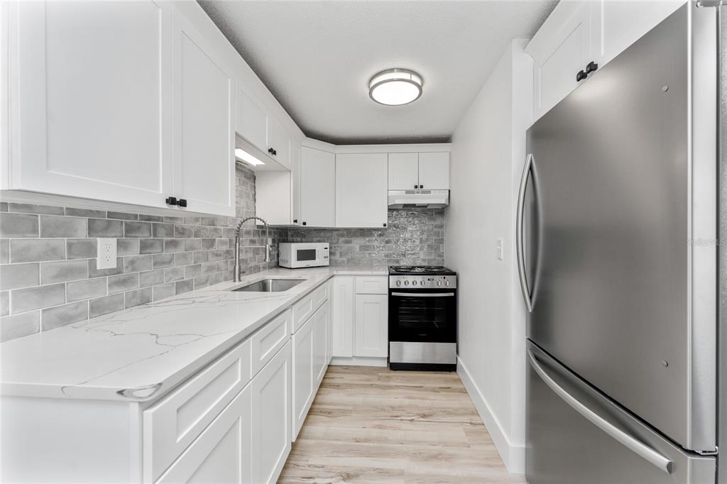 470 South McCall Road, Unit 10 Englewood, FL 34223 - Photo 7 of 57 a kitchen with a sink stove and refrigerator