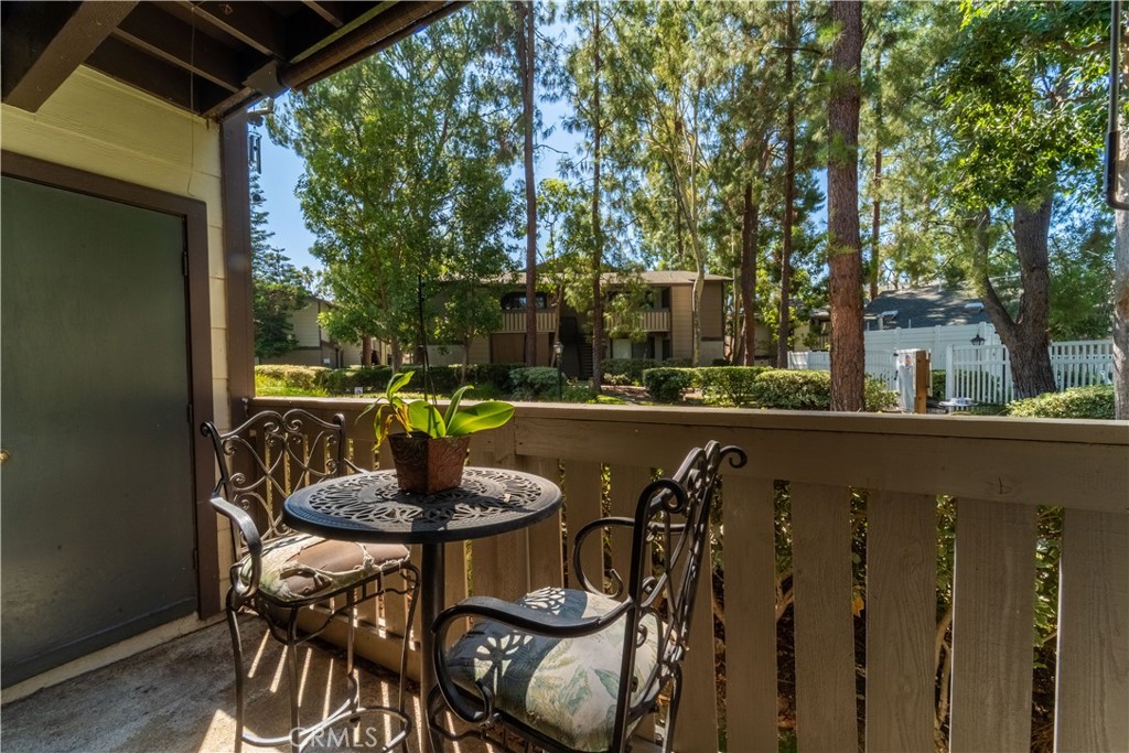 20702 El Toro Road, Unit 413 Lake Forest, CA 92630 - Photo 15 of 29 a view of balcony with table and chairs and wooden fence