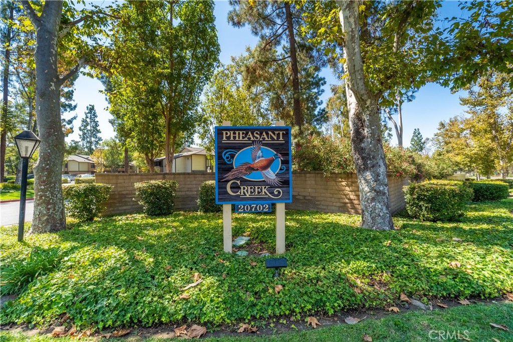 20702 El Toro Road, Unit 413 Lake Forest, CA 92630 - Photo 27 of 29 a sign that is sitting in the grass next to a yard