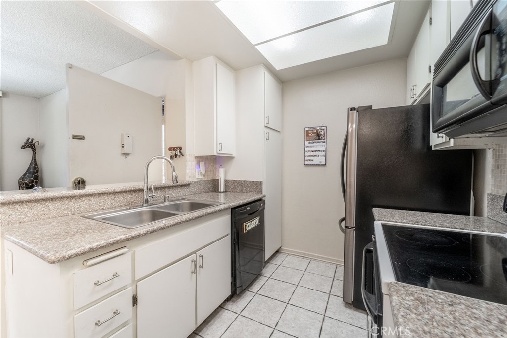 20702 El Toro Road, Unit 413 Lake Forest, CA 92630 - Photo 5 of 29 a kitchen with stainless steel appliances granite countertop a sink stove and refrigerator