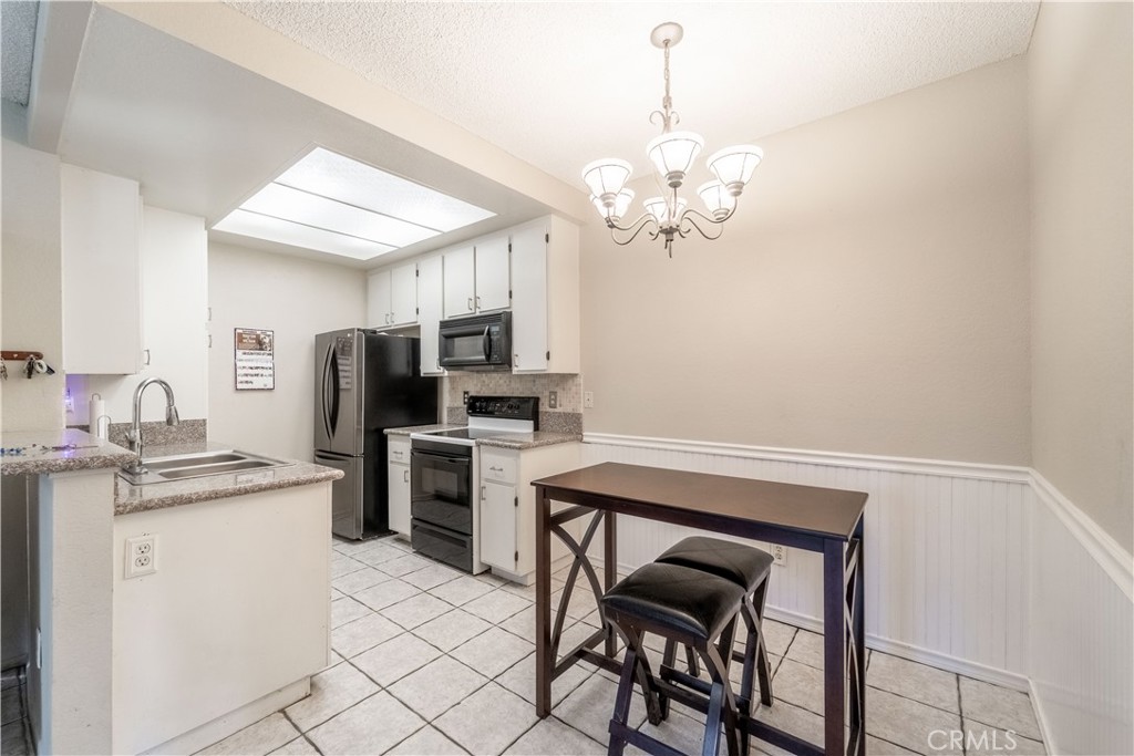20702 El Toro Road, Unit 413 Lake Forest, CA 92630 - Photo 8 of 29 a view of kitchen with stainless steel appliances granite countertop cabinets a sink dishwasher a dining table and chairs
