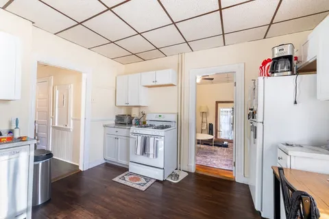 a open kitchen with stainless steel appliances granite countertop a refrigerator and a stove top oven