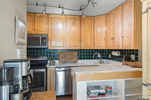 a kitchen with kitchen island a stove a sink and a microwave