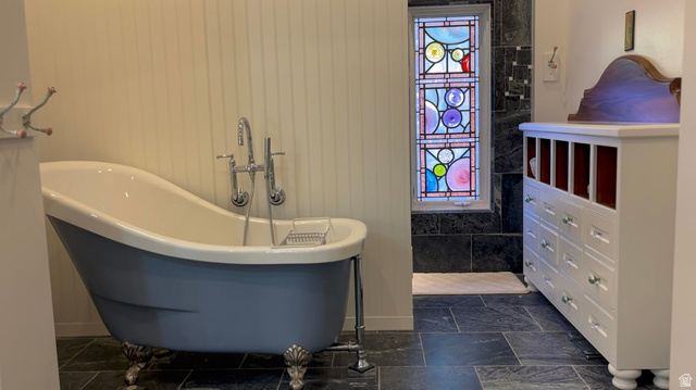 426 West Center Street Parowan, UT 84761 - Photo 28 of 107 Freestanding clawfoot tub with polished chrome fixtures, slate tile flooring, and stained glass window feature