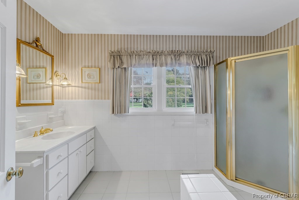 1057 Monaskon Road Lancaster, VA 22503 - Photo 31 of 43 Bathroom featuring an enclosed shower, tile floors, tile walls, and oversized vanity