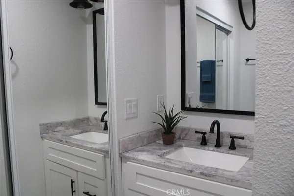 a bathroom with a granite countertop sink and a mirror