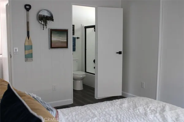 a bedroom with a bed and a painting on the wall