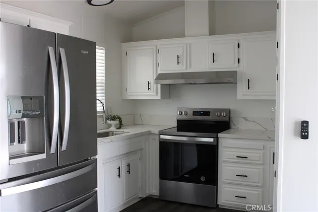 a kitchen with white cabinets and stainless steel appliances