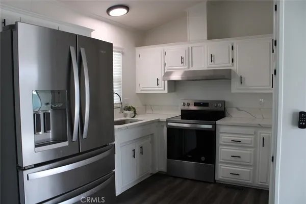 a kitchen with stainless steel appliances white cabinets and a refrigerator
