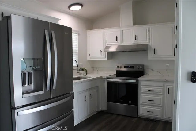a kitchen with stainless steel appliances white cabinets and a refrigerator