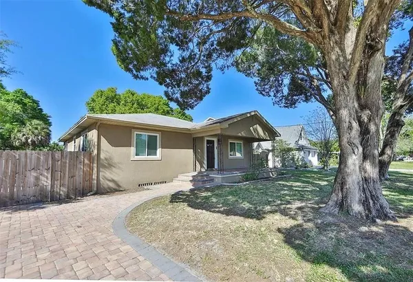 a view of a house with a tree in the yard
