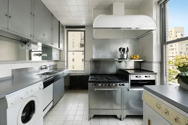 a kitchen with a stove and white cabinets