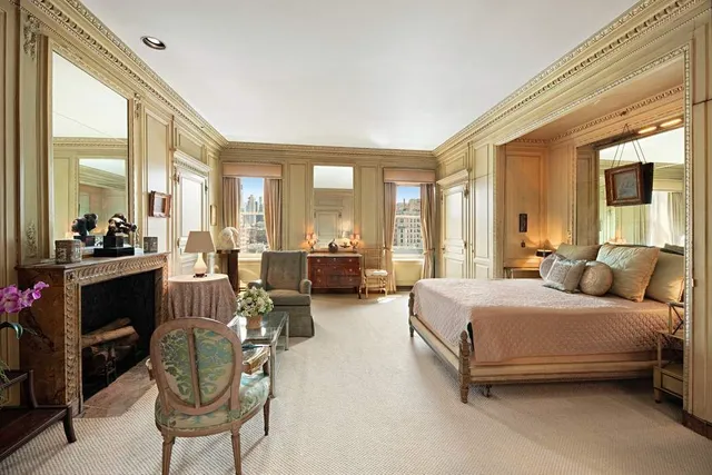 a spacious bedroom with a bed a table and chairs