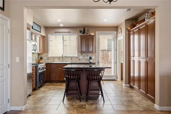 a kitchen with stainless steel appliances granite countertop a stove refrigerator sink and cabinets