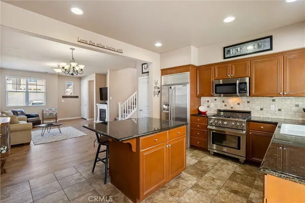 a kitchen with stainless steel appliances granite countertop a stove a refrigerator and a sink